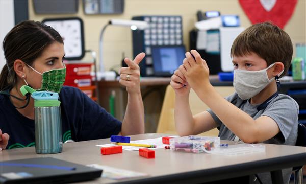 teacher helps student count blocks